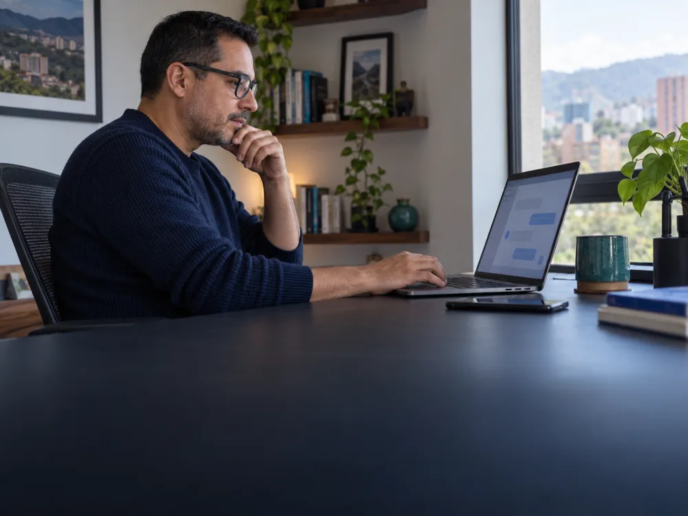 Escena ilustrativa de un asesor trabajando con su computador y celular